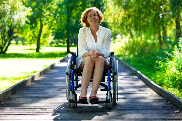 Jeune femme adulte en fauteuil roulant dans le parc — Photo