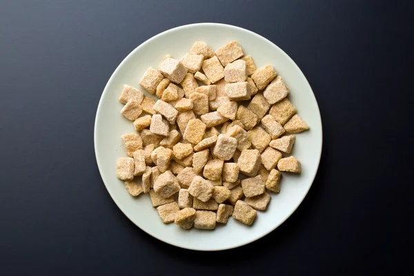 Azúcar de caña sin refinar en el plato — Foto de Stock