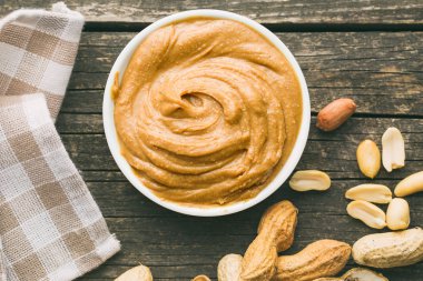 Creamy peanut butter and peanuts. clipart