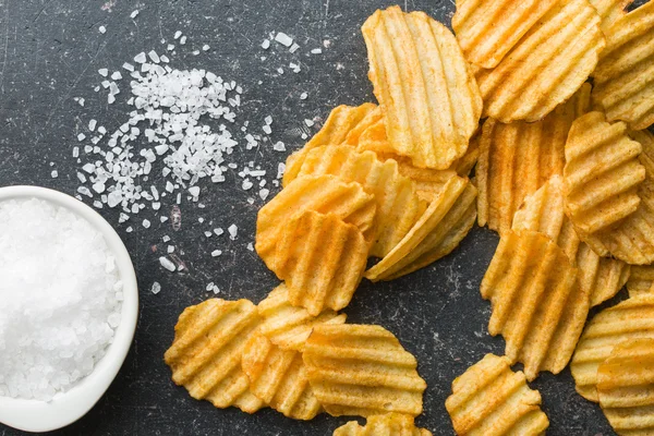 Marszczone wyciąć chipsy z solą. — Zdjęcie stockowe