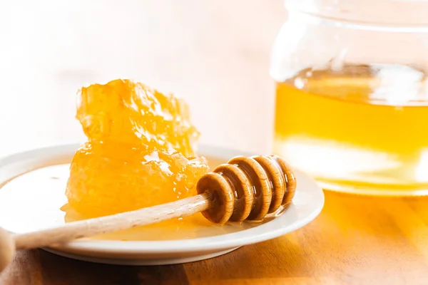 Wooden honey stick and honeycomb. — Stock Photo, Image