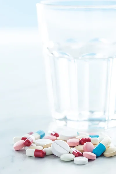 De olika piller och glas vatten. — Stockfoto