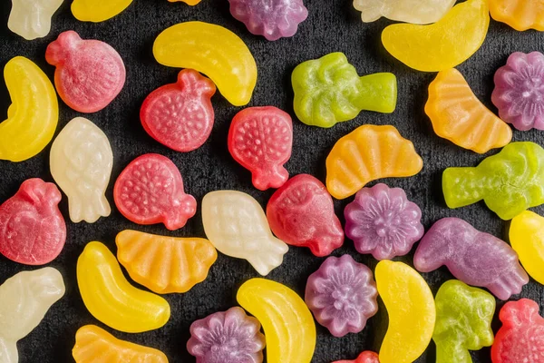 Kleurrijke Fruitige Gelei Snoepjes Zwarte Tafel Bovenaanzicht — Stockfoto