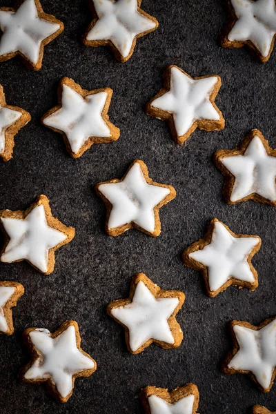 Glassande Pepparkaksstjärnor Traditionella Julkakor Svart Bord Ovanifrån — Stockfoto