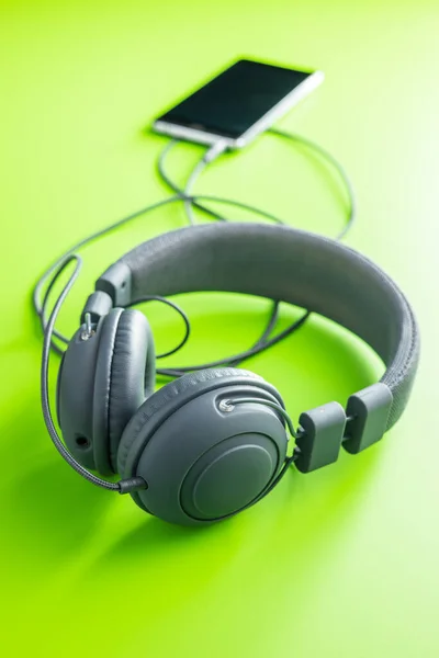 Verkabelte Stereo Kopfhörer Mit Dem Smartphone Auf Grünem Hintergrund Verbunden — Stockfoto