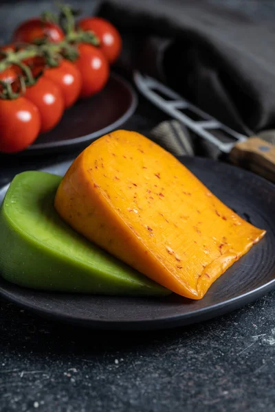 黒皿にチリとわさびの風味を持つハードチーズのブロック — ストック写真
