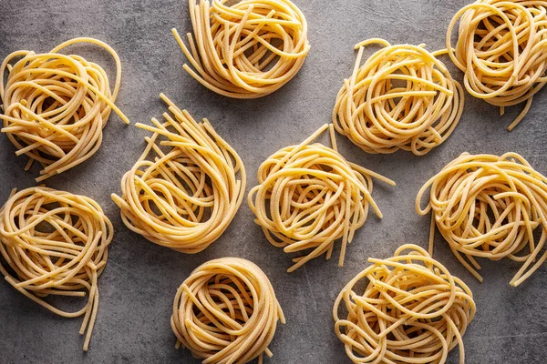 Italské Těstoviny Neuvařené Špagety Hnízdo Kuchyňském Stole Horní Pohled — Stock fotografie