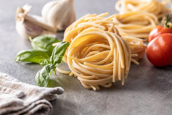 Italiaanse Pasta Nest Basilicum Knoflook Tomaat Ongekookt Spaghetti Nest Keukentafel — Stockfoto