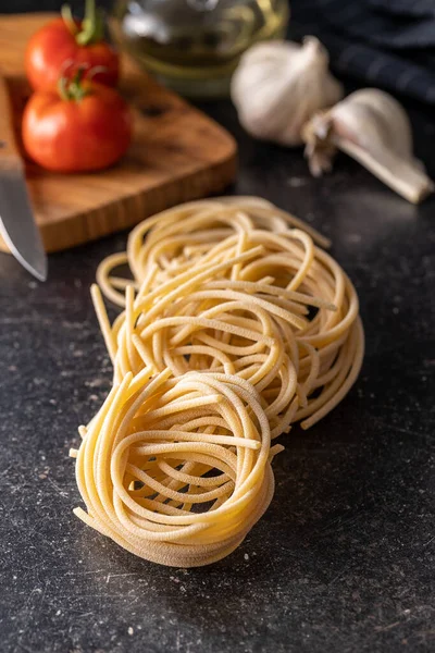 Włoskie Gniazdo Makaronu Niegotowane Gniazdo Spaghetti Czarnym Stole — Zdjęcie stockowe
