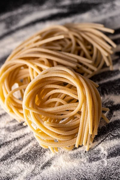 Talyan Makarna Yuvası Pişmemiş Spagetti Yuvası Siyah Masada — Stok fotoğraf