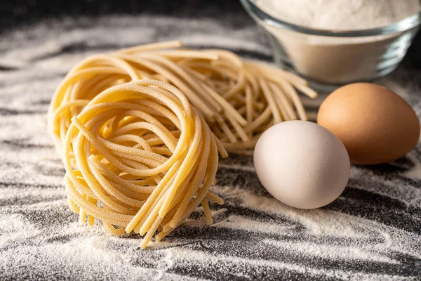 Italian Pasta Nest Uncooked Spaghetti Nest Eggs Flour Black Table — Stock Photo, Image