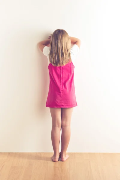 Potret gadis kecil yang sedih berdiri di dekat dinding — Stok Foto