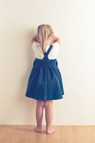 Portret smutny dziewczynka stojący w pobliżu ściany — Zdjęcie stockowe