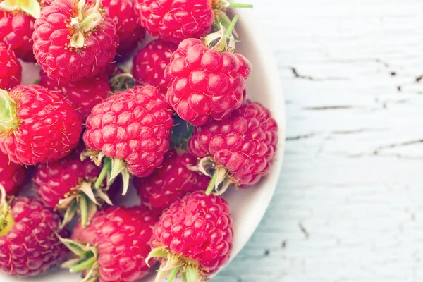 Red raspberries in bowl — Stock Photo, Image