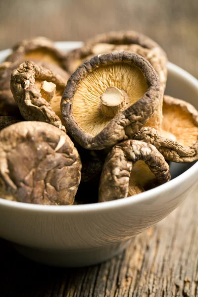 Dried shiitake mushrooms on old wooden table — Stock Photo, Image