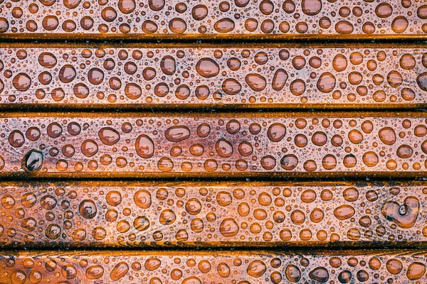 Gotas de agua en mesa de jardín de madera — Foto de Stock