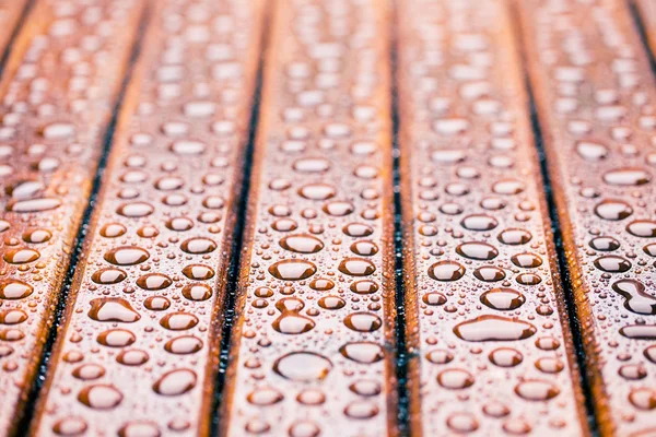 Gouttes d'eau sur table de jardin en bois — Photo