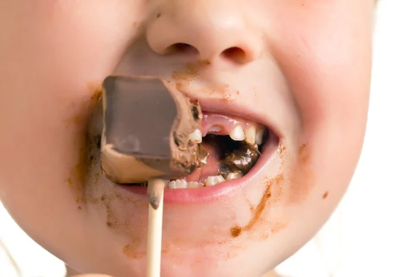 Niño comiendo piruleta de chocolate — Foto de Stock