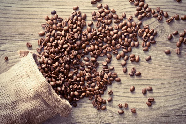 Coffee beans spill out of the sack — Stock Photo, Image