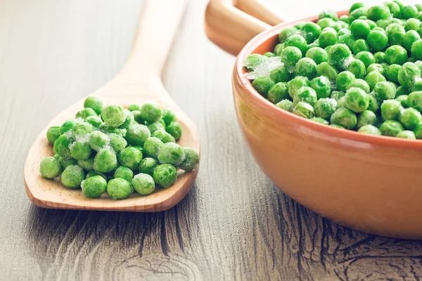 Petits pois surgelés sur cuillère en bois — Photo