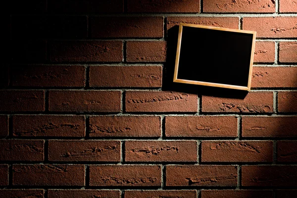 Blank blackboard hanging on brick wall — Stock Photo, Image