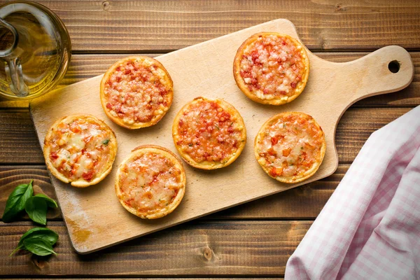 Mini pizza on cutting board — Stock Photo, Image