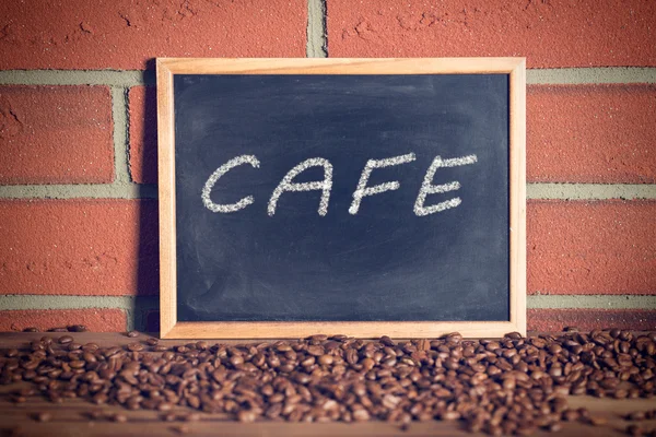 Black chalkboard with coffee beans — Stock Photo, Image