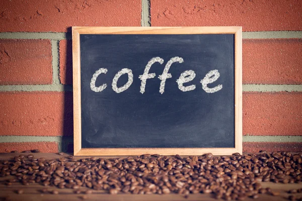 Black chalkboard with coffee beans — Stock Photo, Image