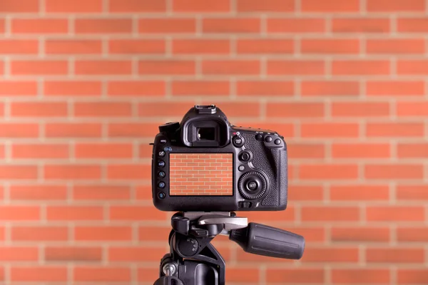 Câmera DSLR na parede de tijolo de tiro tripé — Fotografia de Stock