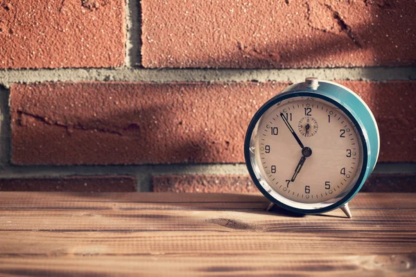 Oude klok in de voorkant van een bakstenen muur — Stockfoto