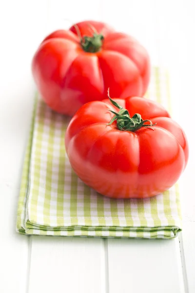 Rode tomaten op witte keukentafel — Stockfoto