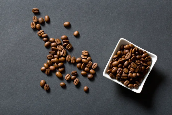 Kaffeebohnen in Schale auf schwarzem Hintergrund — Stockfoto