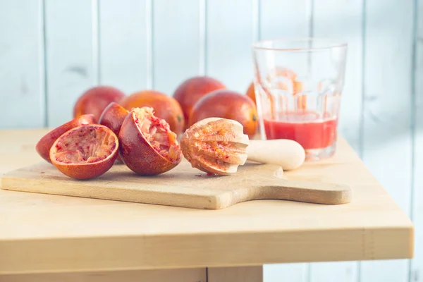 Halveret blod appelsin og saftpresser - Stock-foto