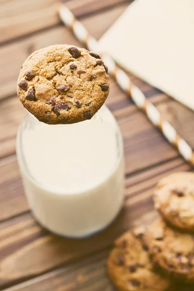 Chocolade koekjes en melk in pot — Stockfoto