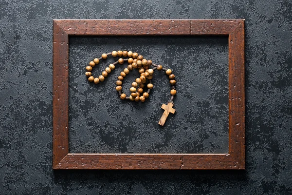 Rosary beads in wooden frame — Stock Photo, Image