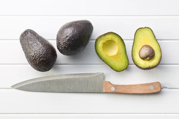Gehalveerde avocado op tafel — Stockfoto