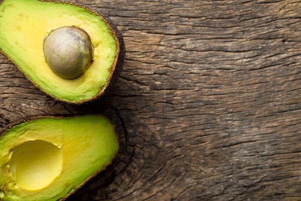 Halved avocado on old table — Stock Photo, Image