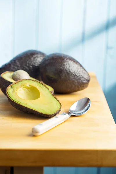 Gehalveerde avocado op de keukentafel — Stockfoto