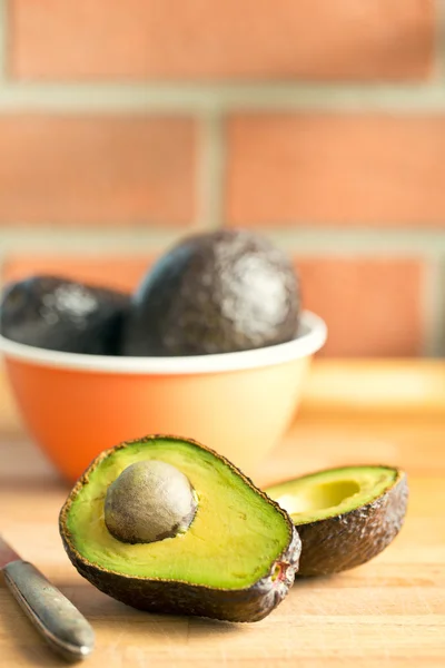 Halved avocado on kitchen table — Stock Photo, Image