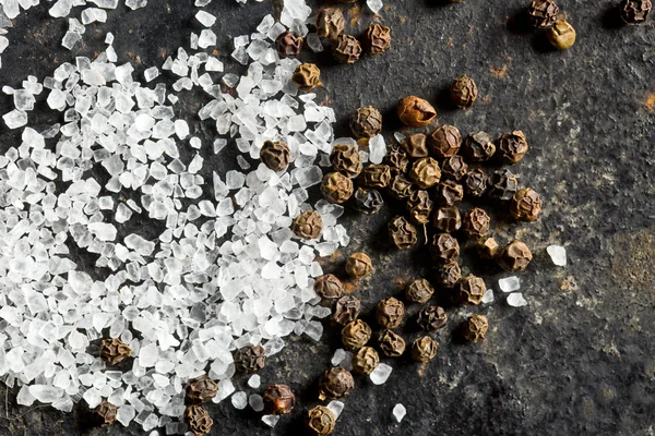 Salt crystals and black peppercorns — Stock Photo, Image