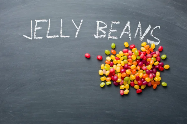 Jelly beans on chalkboard — Stock Photo, Image