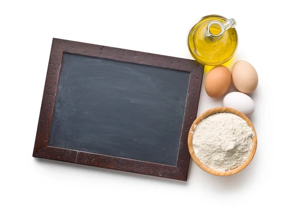 Chalkboard and ingredients for preparing pasta — Stock Photo, Image