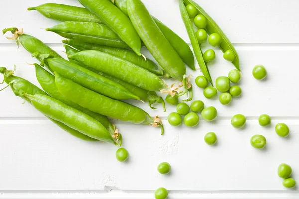 Fresh green peas on kitchen table — Stock Photo, Image