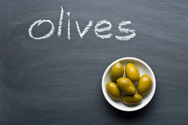 Green olives on blackboard — 스톡 사진