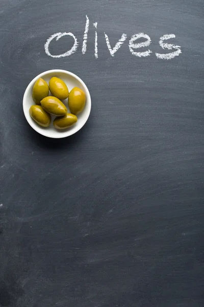 Green olives on blackboard — 图库照片