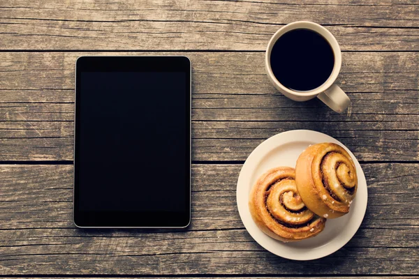 Rotoli di cannella, tazza di caffè e tablet per computer — Foto Stock