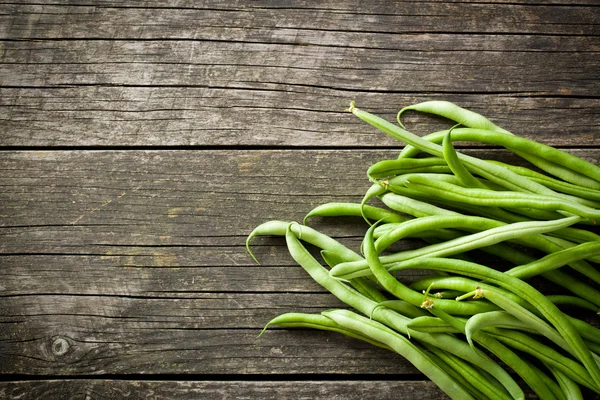 Green beans on old table — Stock Photo, Image