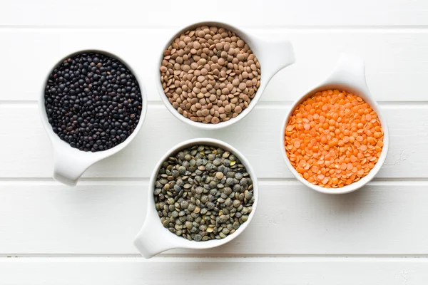 Various lentils in ceramics bowls — Stock Photo, Image