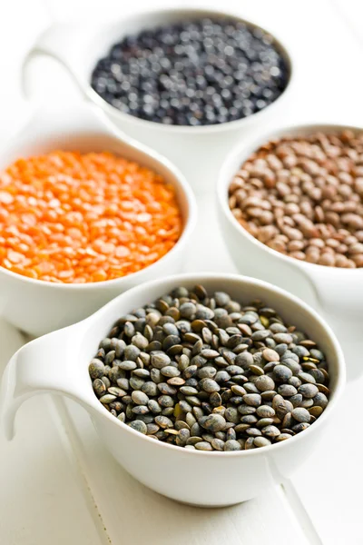 Várias lentilhas em taças de cerâmica — Fotografia de Stock