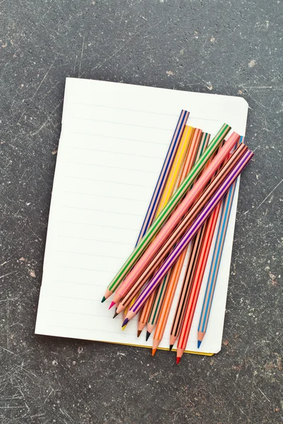 Colour pencils and blank workbook — Stock Photo, Image